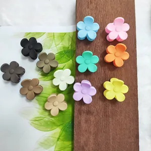 Detailed view of colorful flower-shaped hair claw clips in matte macaron and earth tones