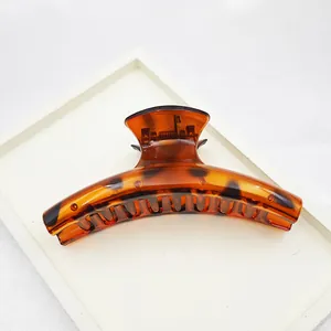 Close-up of a large tortoiseshell hair claw clip with a glossy finish on a white tray