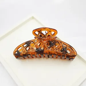 Macro view of large leopard print hair claw clip showing hollow-out lattice design detail