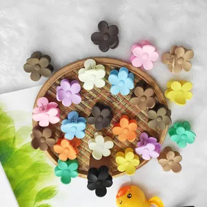Close-up of matte mini flower hair claws in assorted macaron and Maillard earth tones