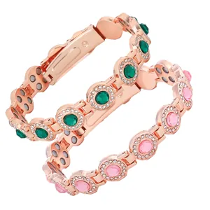 Detail of rose gold magnetic bracelets featuring emerald green and pink stones.