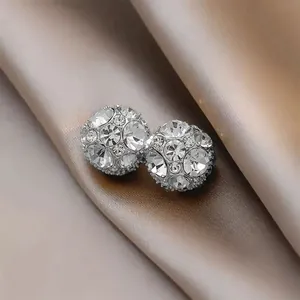 Macro view of silver-toned magnetic sphere earrings encrusted with clear rhinestones