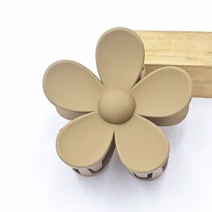 Macro detail of the matte beige flower hair claw clip showing the frosted surface texture
