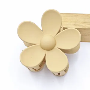 Close-up of a matte beige five-petal flower hair claw clip on a white background