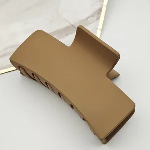Detailed view of a matte square hair claw clip in camel color with fine texture