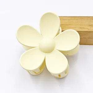 Matte pale yellow flower hair claw clip with five petals for elegant hairstyling.