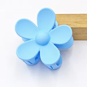 Close-up of light blue matte flower hair claw clip with five-petal design