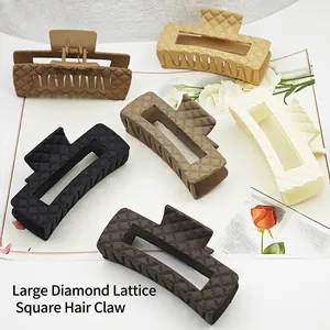 Detailed view of large matte hair claw clips with quilted diamond pattern in neutral colors