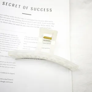 Primer plano de una pinza para el pelo blanca brillante sobre un fondo de libro sutil