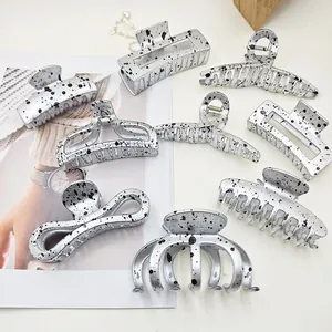 Collection of silver metallic hair claw clips featuring artistic black splatter pattern designs