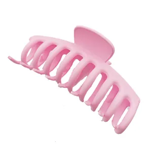 Primer plano detallado de una pinza para el cabello rosa mate grande para pelo