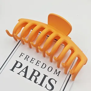 Vista detallada de pinza para el cabello grande naranja mate para peinado de mujer