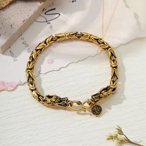 Detailed view of retro gold-finish dragon head bracelet with punk totem pattern details.