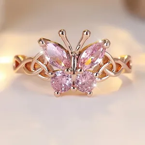 Exquisite macro detail of a rose gold butterfly ring with sparkling pink gemstones.