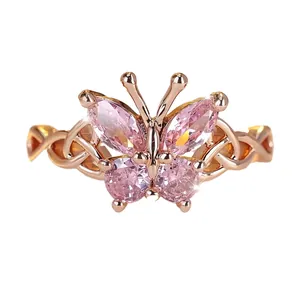 Close-up of a rose gold butterfly ring with elegant pink marquise and round crystals