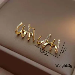 Detailed side view of sparkling gold claw earrings with 1.4cm and 1cm size markers