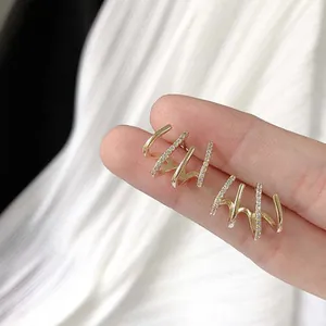Detailed view of elegant golden claw earrings with shimmering micro-pave crystals
