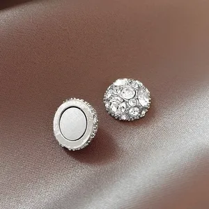 Macro view of crystal encrusted magnetic ear studs for non-pierced ears on brown background