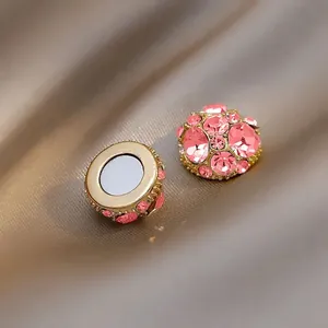 Detailed macro shot of pink crystal magnetic non-piercing earrings in gold-tone base.