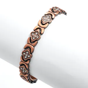Primo piano del bracciale magnetico a quadrifoglio in oro rosa con strass bianchi
