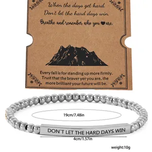 Macro detail of stainless steel beaded bracelet with engraved bar and gift card