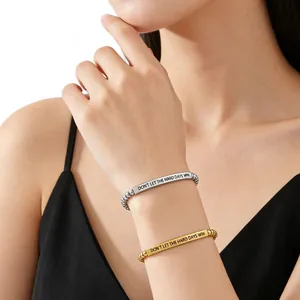 Detail view of engraved stainless steel beaded bracelets with motivational quote on wrist