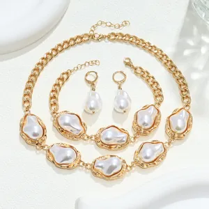 Primo piano di un set di gioielli con perle barocche, collana e bracciale in metallo dorato