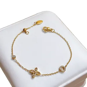 Detailed view of gold bracelet featuring a four-petal crystal flower and sparkling charms
