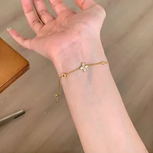 Detailed view of elegant gold adjustable four-leaf flower crystal bracelet on a lady wrist