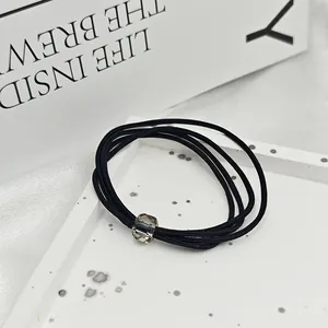 Gros plan sur un élastique à cheveux noir haute élasticité avec perle de cristal facettée