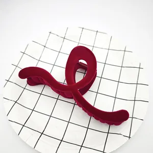 Primer plano de una pinza para el cabello de terciopelo granate en un plato moderno