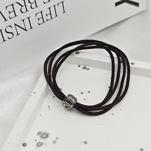 Vue détaillée d'un élastique à cheveux marron foncé avec perle de cristal