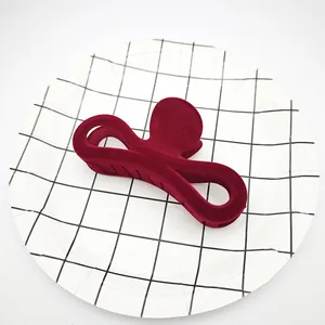 Vista detallada de una pinza para el cabello flocada granate con acabado de terciopelo