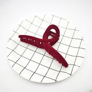 Primer plano de una pinza para el pelo de terciopelo burdeos sobre un plato de rejilla