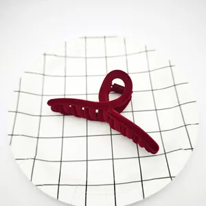 Vista detallada de una pinza para el cabello de terciopelo flocado color burdeos