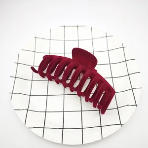Vista detallada de una pinza para el pelo de terciopelo burdeos en plato de rejilla