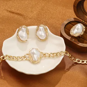 Detail view of a vintage baroque pearl jewelry set featuring a ring, earrings and bracelet.