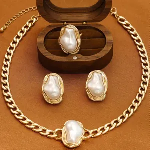Luxury baroque pearl jewelry set with gold curb chain necklace, earrings, and ring.