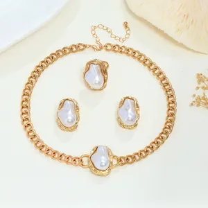 Vintage gold baroque pearl jewelry set including necklace, earrings, and ring.