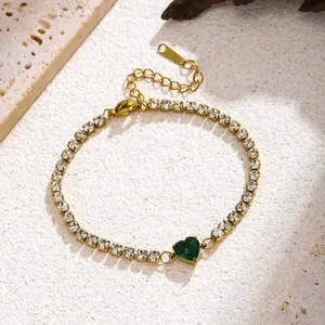 Close-up of a gold titanium steel bracelet with green heart zircon and clear stones