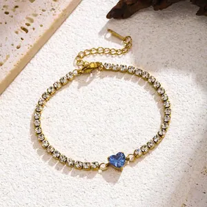 Detail shot showing the sparkling blue heart-shaped zircon and clear rhinestones on gold.