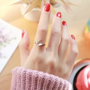 Close-up of minimalist rose gold butterfly ring with frosted wing detail worn on finger