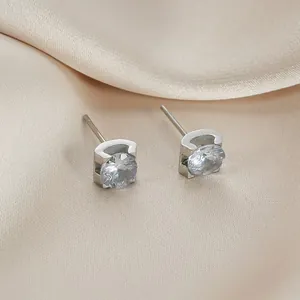 Dettaglio di orecchini a lobo minimalisti in acciaio al titanio argento con castone a toro e CZ