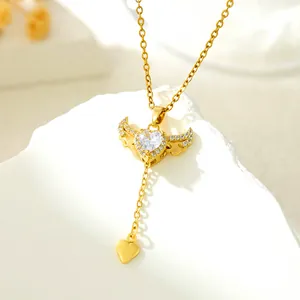 Close-up of gold angel wings heart pendant necklace with shimmering crystals and stones.