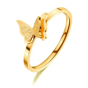 Close-up of double-layered butterfly ring with frosted and polished gold texture.