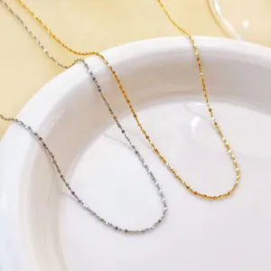 Close-up of minimalist stainless steel thin chain necklaces in gold and silver finish.