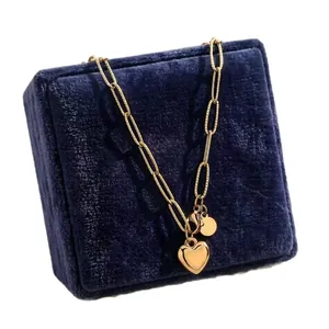 Gros plan détaillé d'un collier pendentif cœur doré sur un écrin à bijoux en velours bleu