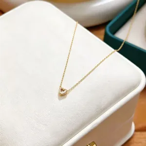 Detailed close-up of an elegant gold heart pendant necklace with shimmering zircon stones