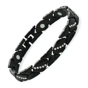Detailansicht eines schwarzen magnetischen Armbands in Blattform mit Strasssteinen.