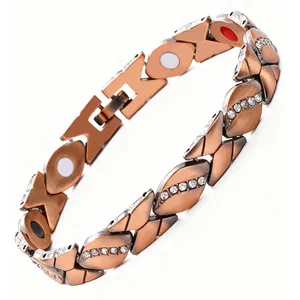 Detail eines antiken roten Kupfer-Magnetarmbands mit Blattdesign und Strasssteinen